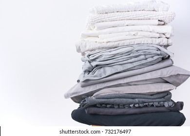 stacks different shades grey white black bed linen textiles clothing background pile concept