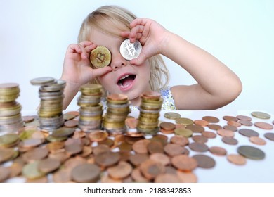 Stacks Of Euro Currency Coins, Small Child, Blonde Girl 3 Years Old Holds Bitcoin Crypto Currency Coins In Hands, Financial Literacy Of Children, Electronic Decentralized Money, Bitcoin Glasses