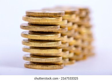 Stacks of gold coins in staggered order, close-up on a light background