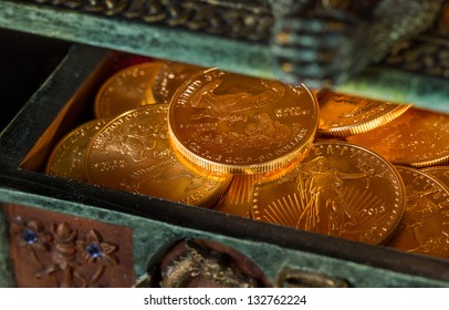 Stacks Of Gold Eagle One Troy Ounce Golden Coins From US Treasury Mint In Old Carved Pirate Treasure Chest