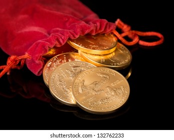 Stacks Of Gold Eagle One Troy Ounce Golden Coins From US Treasury Mint Pouring From Mouth Of Red Velvet Money Bag