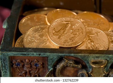 Stacks Of Gold Eagle One Troy Ounce Golden Coins From US Treasury Mint In Old Carved Pirate Treasure Chest