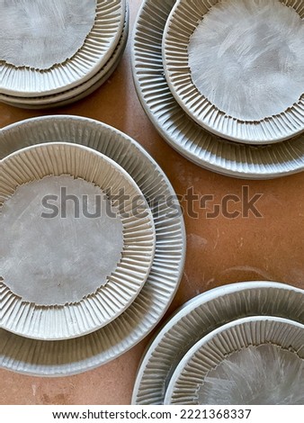 Stacks of leather hard ceramic plates before being bisque fired