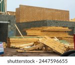 Stacks of lumber by two single-family bilevel houses under construction next to each other in a suburban residential development in southwest Florida, for motifs of supply and demand