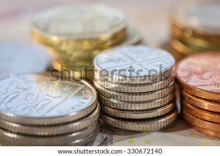 Stacks of money, UK coins of one, five, ten and twenty pence and pound coins