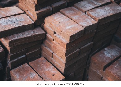 Stacks of newly made solid bricks made from clay (baked earth) used for landscaping, and other building and construction purposes. Selective focus.