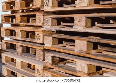 Stacks Of Old EUR Symbol Wooden Pallets In An Industrial Yard.