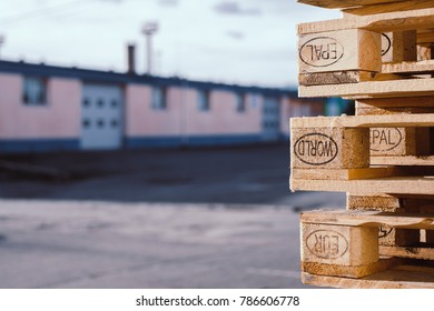 Stacks Of Old EUR Symbol Wooden Pallets In An Industrial Yard.