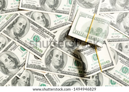 Stacks of one hundred dollars banknotes close-up on dollar background business concept top view with copy space.