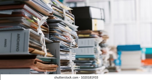 Stacks of paperwork and files in the office: work overload, files management and administration concept - Shutterstock ID 1020181933