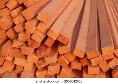 Stacks Of Pine Wood Planks Covered With Primer Paint In A Store Or On A Building Site. Natural Rough Wooden Boards, Lumber, Industrial Wood, Timber