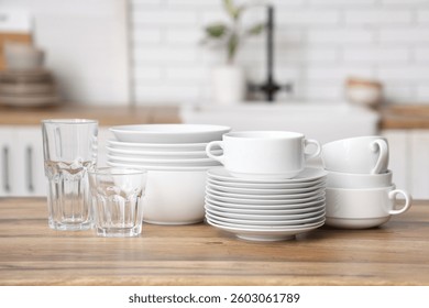 Pilas de platos y tazas en la mesa de madera en la cocina