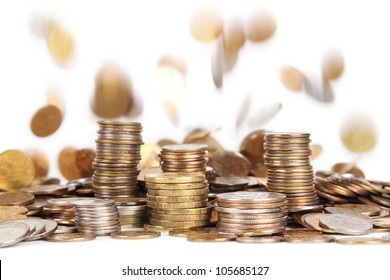 stacks of silver and golden coins and falling coins on background isolated