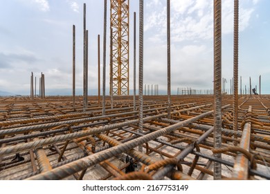 Stacks of square metal and rusty reinforcing rods and mesh for building construction. Reinforcing frame of the base plate. Reinforcing metal frame for pouring concrete on a construction site.