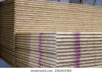 stacks of tongue and groove water resistant OSB compressed sawdust sheets. - Shutterstock ID 2362421983