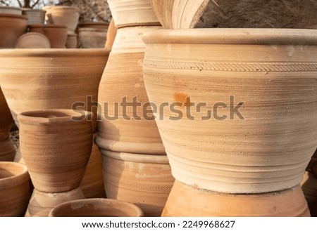 Stacks of various terracotta pots for plants for sale at a garden store.