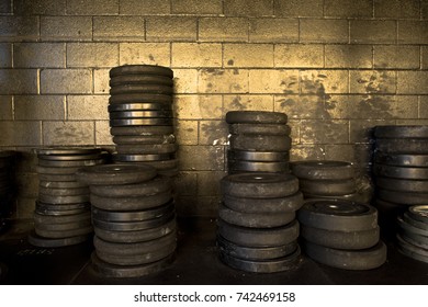 Stacks of weights at a gritty gym in San Diego are illuminated by the sun. 