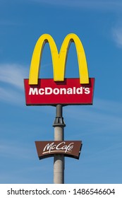 Stade, Germany - August 22, 2019: Logos Of McDonalds And McCafé On A Pole Against Blue Sky.