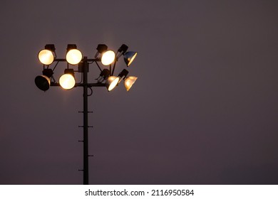 Stadium Light Pole Holding Many Light Fixtures Against A Dark Moody Sky