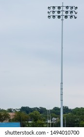 Stadium Lights And Bleachers At Football Game At Local High School During Day Game (lights Not On) With Open Space In Sky.