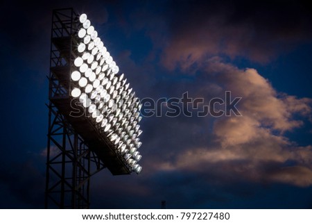 Stadium Lights standing tall in the clouds on a summer night.