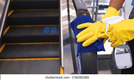 Staff Cleaning The Escalator Hand Rail In Department Store To Prevent The Spread Of Pandemic Covid-19 And Coronavirus, Healthcare And Hygiene Concept