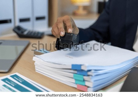 Staff are collecting data from piles of documents and sorting them into categories.