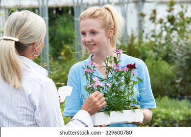 Staff Giving Plant Advice To Female Customer At Garden Center - Shutterstock ID 329600780