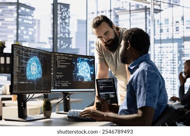 IT staff members testing and deploying artificial intelligence programs and systems. Team of computer scientists checking AI code, sitting at desk chair in office, doing brainstorming