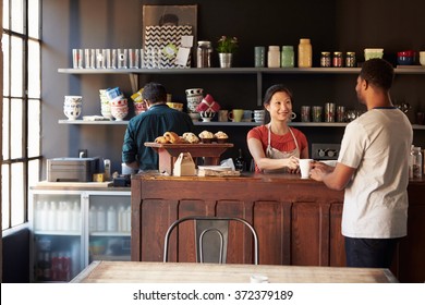 Staff Serving Customer In Busy Coffee Shop - Powered by Shutterstock