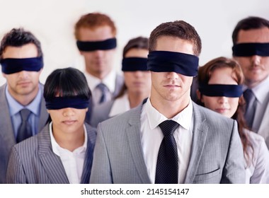 Staff training is paramount to a capable team. Shot of a group of businesspeople all wearing blinfolds.