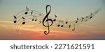 Staff with treble clef and musical notes against sunset sky, banner design