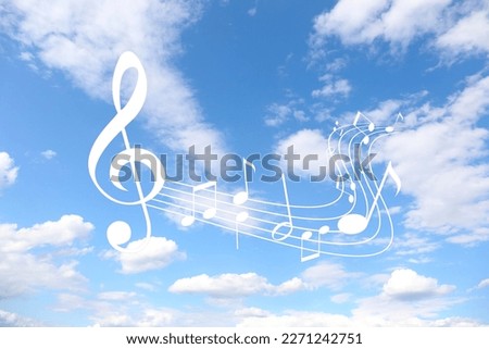 Staff with treble clef and musical notes against sky