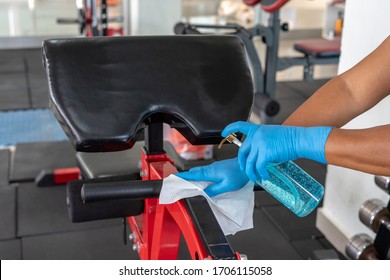 Staff using wet wipe and disinfectant from the bottle spraying sit up bench in gym. Antiseptic,disinfection ,cleanliness and healthcare. Anti bacterial and Corona virus COVID19. - Powered by Shutterstock