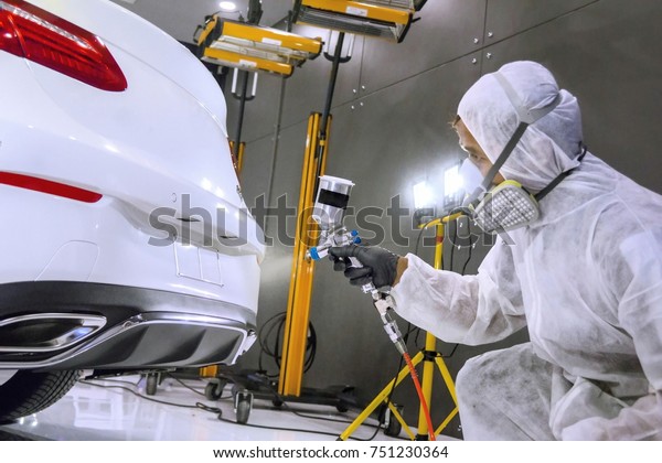 Staff wear\
Chemical protective clothing at work.Car Care Business. Automobile\
industry. Car wash and coating business with ceramic\
coating.Spraying the varnish to the\
car.