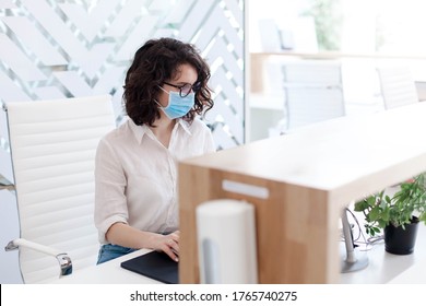 Staff Wearing Protective Mask At Hotel Reception. Protection Employees On Workplace. Young Woman Working In Safety Office As Receptionist. Social Distance During Coronavirus Quarantine.