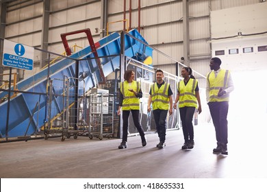 Staff wearing reflective vests in an industrial interior