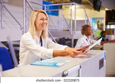 Staff Working At Airport Check In Desk