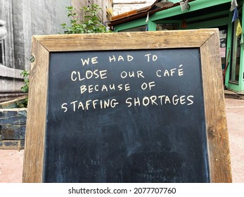 Staffing shortages sign at closed business due to lack of staff, employee shortage
