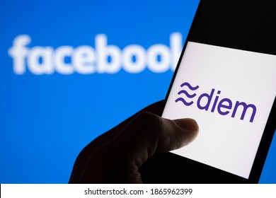 Stafford, United Kingdom - December 1 2020: Diem currency logo on the smartphone silhouette and blurred Facebook logo on the background. 