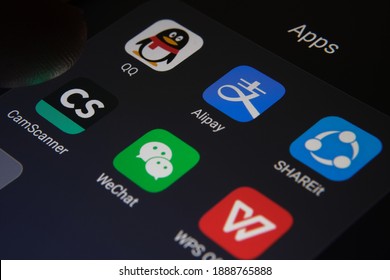 Stafford, United Kingdom - January 6 2021: Alipay, WeChat, QQ, SHAREit, CamScanner, WPS Office apps seen on the screen and blurred finger on top of them. Banned Chinese aps in the US. Concept.