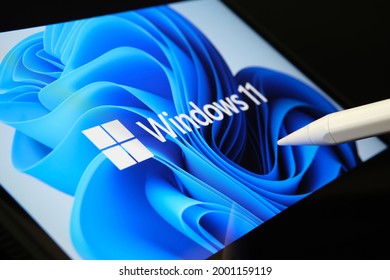 Stafford, United Kingdom - July 1, 2021: Microsoft Windows 11 operating system logo seen on the screen of tablet and user pointing at it with stylus. 