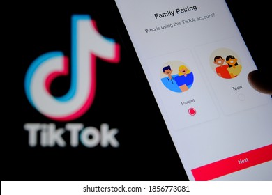 Stafford, United Kingdom - November 18 2020: TikTok App Parental Control Page On The Screen Of Smartphone, Finger Touching It And The Blurred TikTok Logo On The Background. 