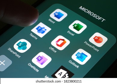 Stafford / United Kingdom - September 29 2020: Microsoft Office 365 products as mobile apps seen on the screen of smartphone and blurred finger pointing at them.