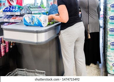 Staffordshire, England - Agust 9, 2019: Tight Crop Of Female Customers At Supermarket Checkout Paying For Their Goods