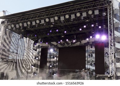 Stage For Concert Or Show Under Blue Sky. Light, Sound And Video Equipment On Metal Frame Construction Installed Outside. No People At Day Time