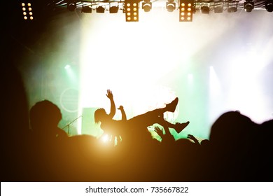 Stage Diving. Crowd Surfing During A Musical Performance. Silhouette Of Man.