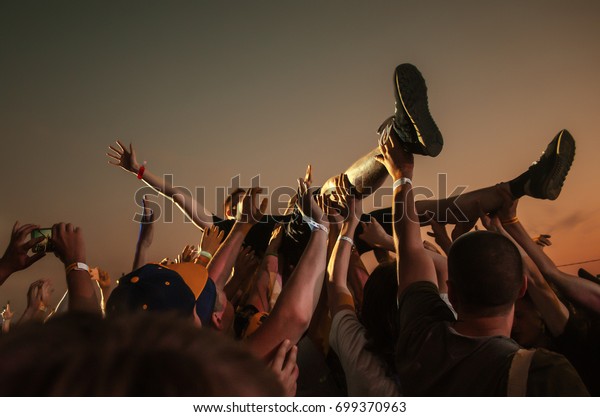 Stage\
diving. Crowd surfing during a musical\
performance