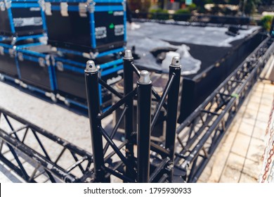 Stage light equipment boxes and metal frame, closeup of photo. Stack of metal trusses for mounting the stage.