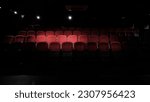 stage light hitting red cloth seats in theater , movie theater